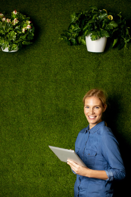 young-woman-posing-with-digital-tablet-by-green-wall (1)